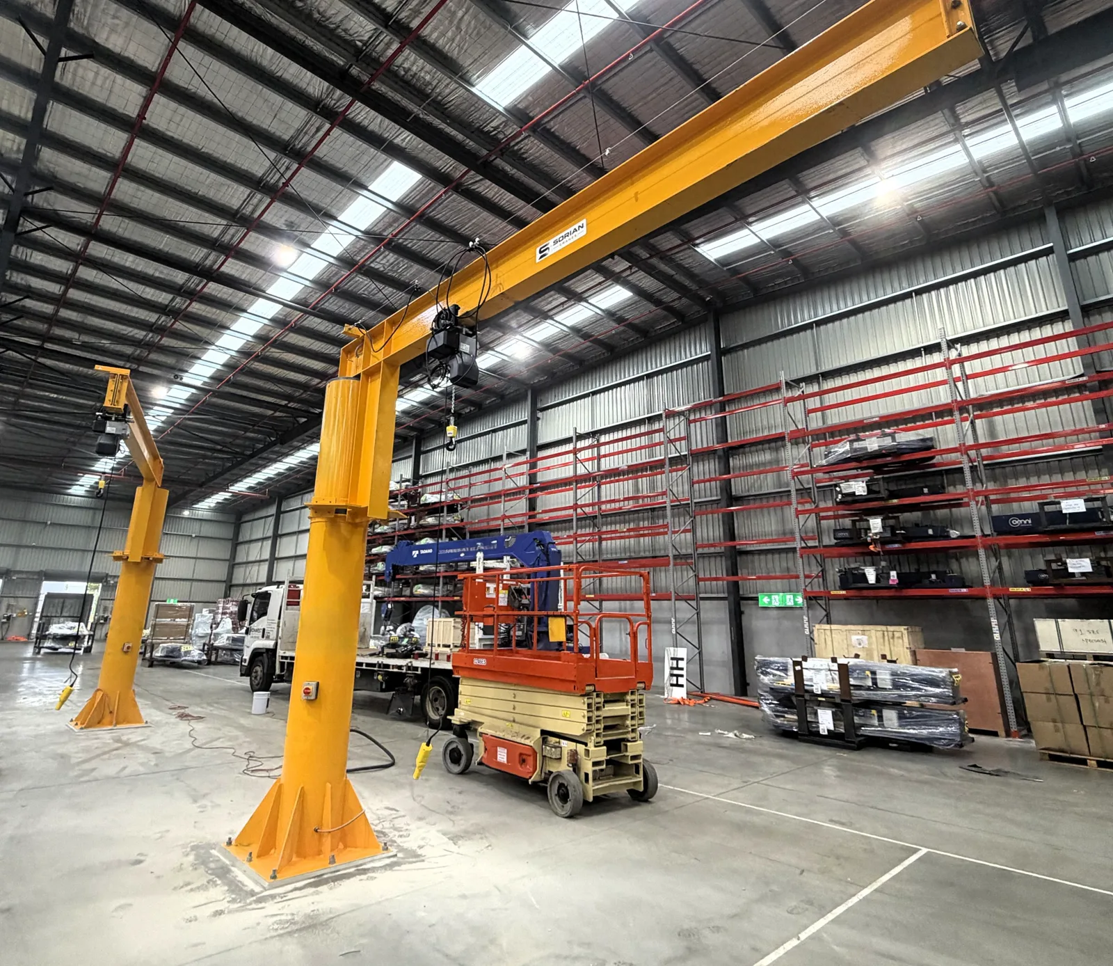 Two Sorian free-standing jib cranes bolted to base plates in a Victorian warehouse
