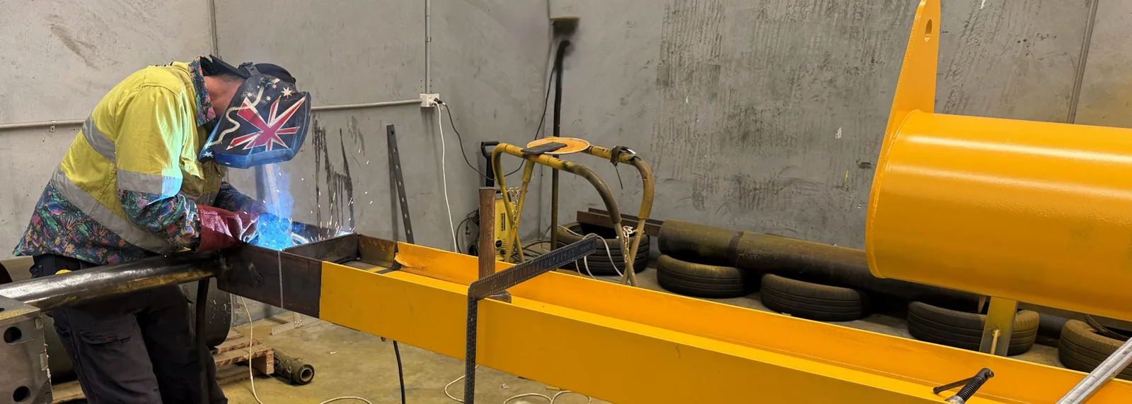 Boilermaker welding a Sorian jib crane arm module in the workshop before painting
